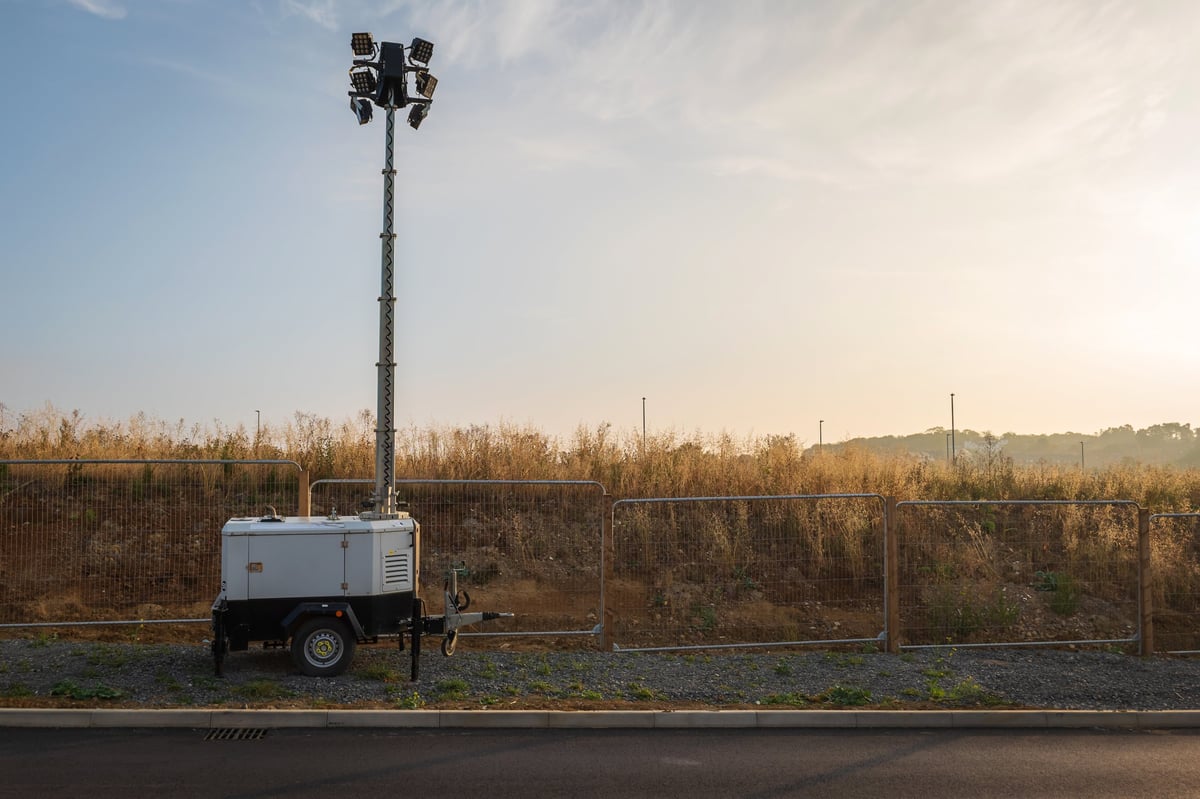 Mobile light towers illuminating a construction site at dusk, the kind of site lighting equipment CBB Group helps contractors finance