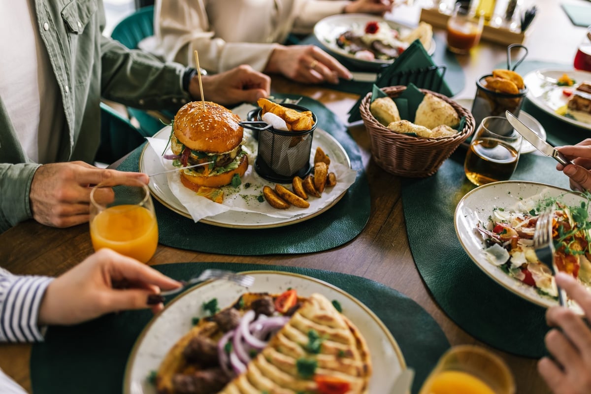 Friends eating lunch together in a restaurant — a full dining room, the kind of business CBB Group arranges restaurant financing for