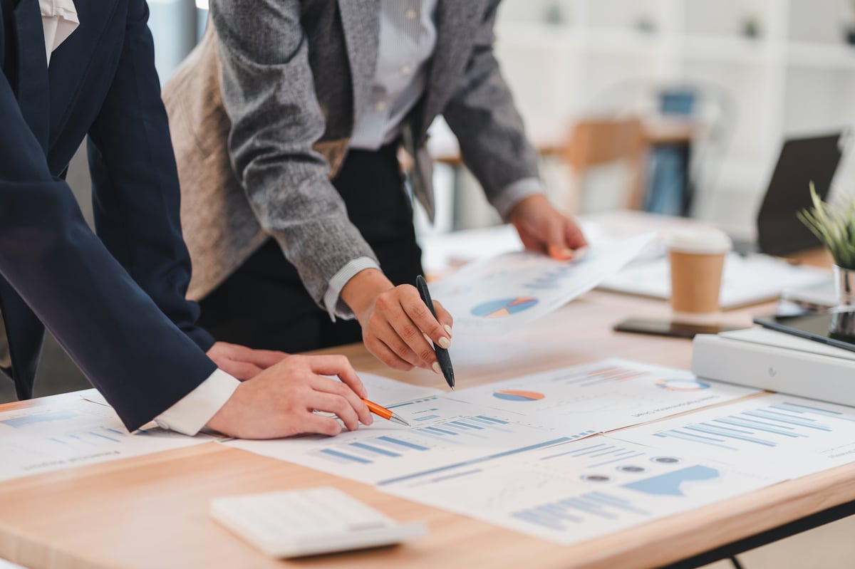 Two business professionals reviewing company financial documents together at a desk