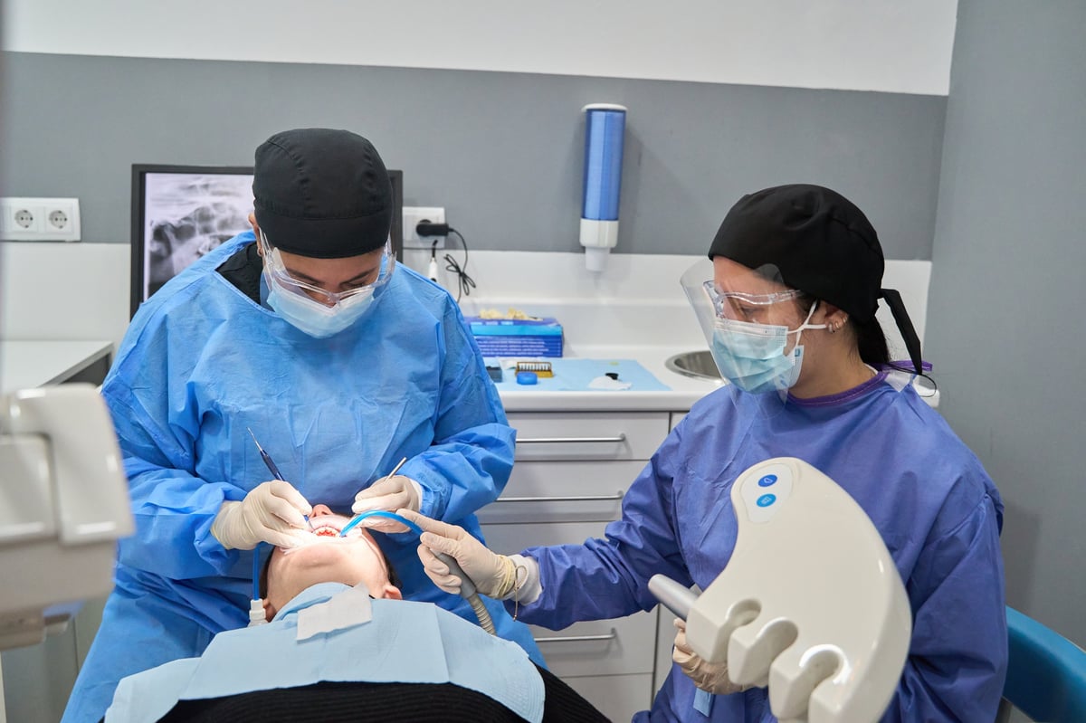Dentists using specialized equipment during a procedure in a dental clinic
