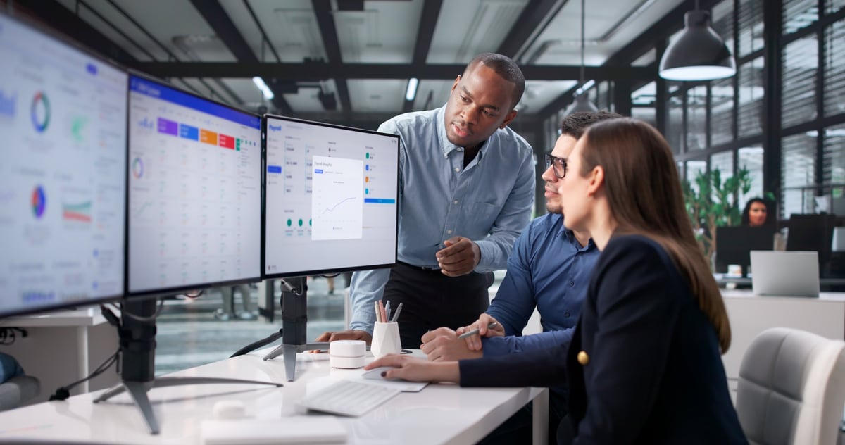 A busy open-plan office with a team of people working together at desks