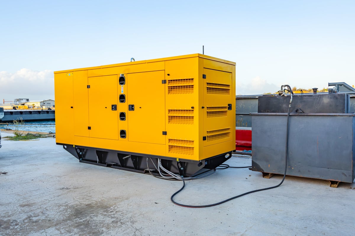 A large mobile diesel generator in a yellow soundproof canopy outdoors, the kind of portable power equipment CBB Group arranges financing for