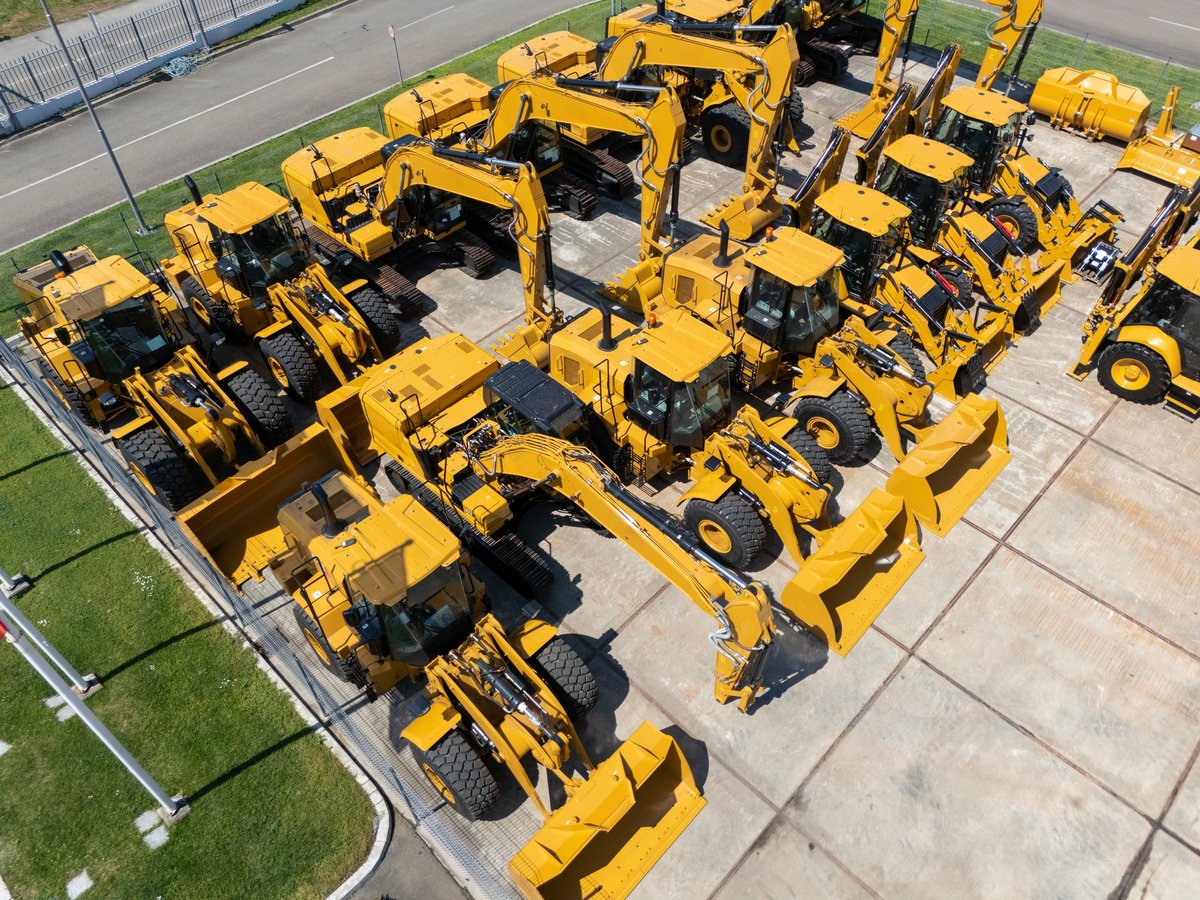 New hydraulic excavators and tractors parked at a construction machinery dealership